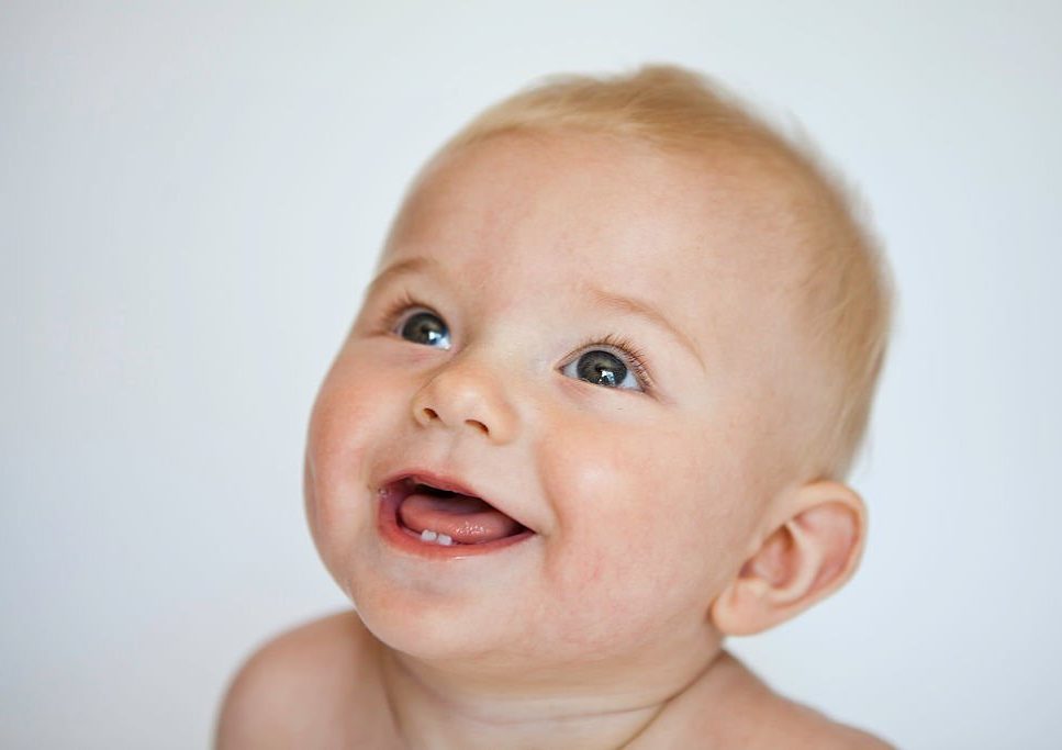 Little toddler is happy and showing off his first two teeth.